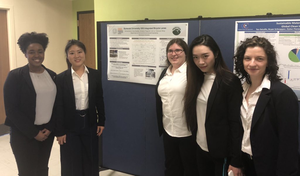 Simone and four other students stand in front of a research poster