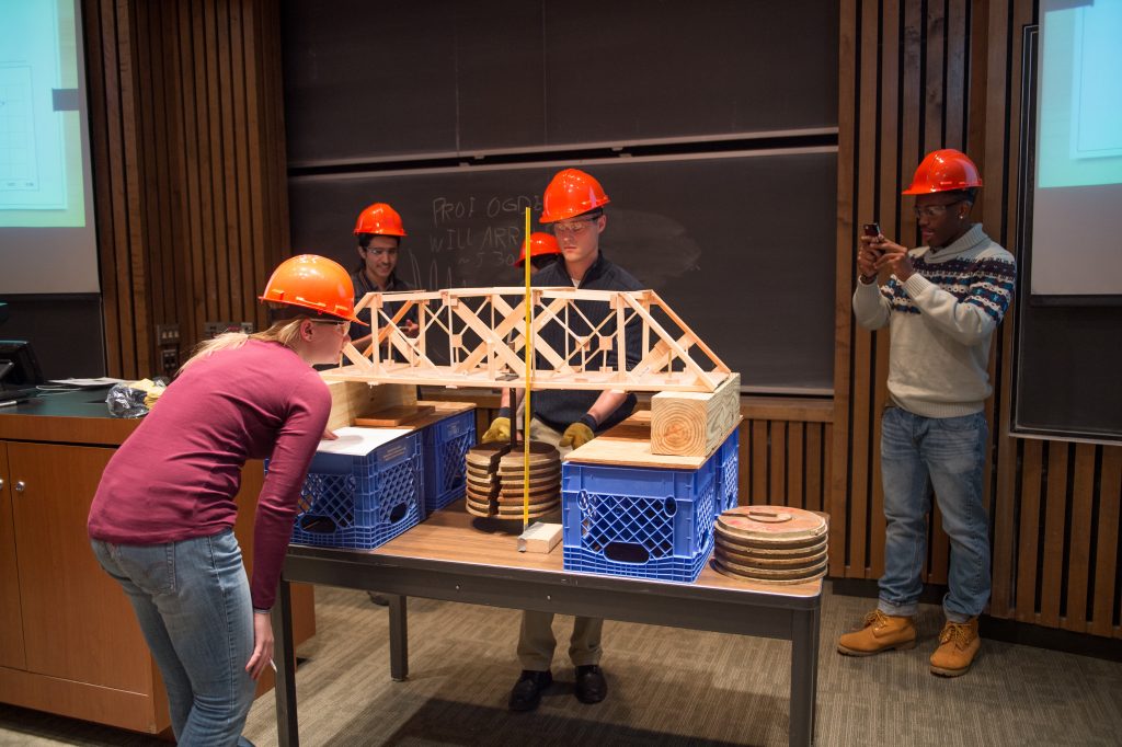 Civil engineering students test the bridge they built as part of the ECS 101 end-of-semester competition.